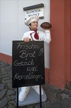 Baker figure with chalkboard in front of the monastery shop