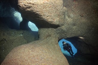 Diver exploring a cave with three entrances