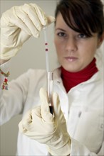 Female laboratory assistant in the laboratory holding a blood sample