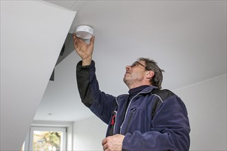 Caretaker with smoke detector in a stairwell