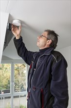 Caretaker with smoke detector in a stairwell