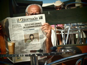 Man reading an Italian newspaper in a cafe in the morning