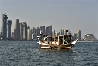 Wooden boat in front of skyscraper skyline