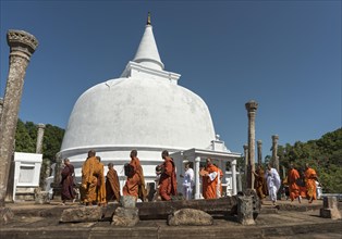 Buddhist monks walk around Lankaramaya Dagoba