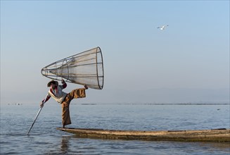 Intha fisherman fishing with traditional conical fishing net
