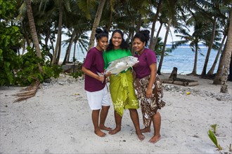 Samoan girls holding their fresh catch