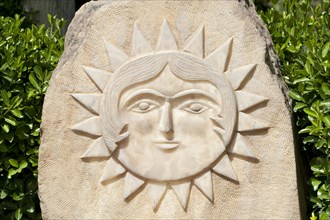 Sun with face carved in stone