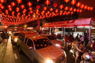 Red chinese lanterns reflecting on cars