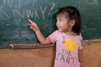Little girl student pointing to a blackboard
