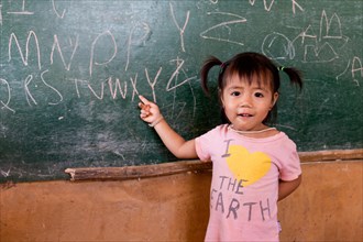 Little girl student pointing to a blackboard