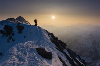 Sunrise above the Allgau Alps with mountaineer in front of Gaisshorn summit