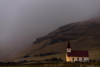 Reyniskirkja church with fog-covered mountains
