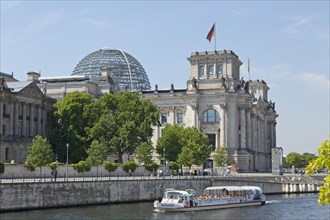 Reichstag parliament with sightseeing boat on the Spree river