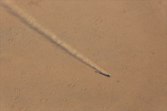 A vehicle of the balloon ground crew crossing a sandy plain at the edge of the Namib Desert