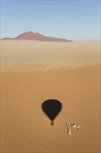 Shadow of a hot-air balloon at the intended landing spot in a true desert environment