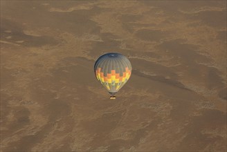 Hot-air balloon above an arid plain at the edge of the Namib Desert