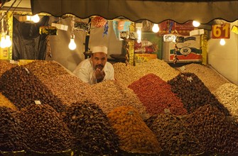 Man selling dried fruit and nuts at a market stall