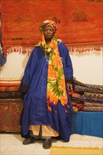 Colourful outfit of an employee in a carpet shop in Tafraoute