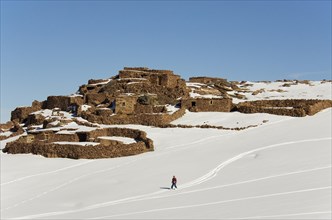 Snow covered Berber village and skier near to the Oukaimeden skiing centre in the High Atlas mountains