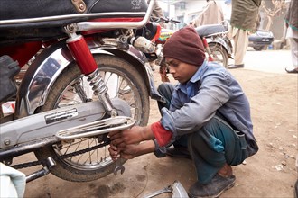 Young guy is repairing a motorcycle