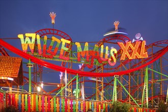 Wild Mouse ride on the fun fair Bremer Freimarkt at dusk