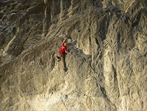 Climber lead climbing on a rock face
