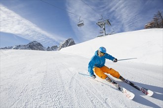 Skier with a helmet skiing down a slope