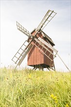 Old fashioned wooden windmill on a hill