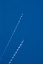 Contrails of two aircrafts in a blue sky