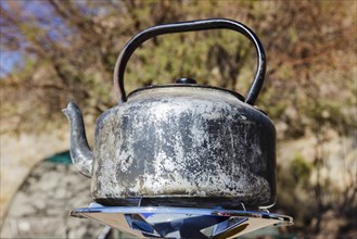 Heavily worn kettle on gas cooker