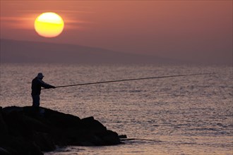 Angler in the backlight at dawn