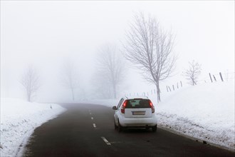Car on a country road in a snow-covered landscape