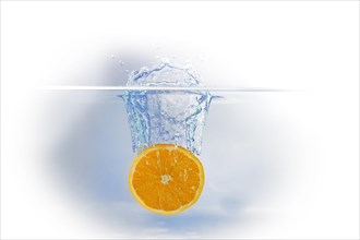 A slice of orange falling into water