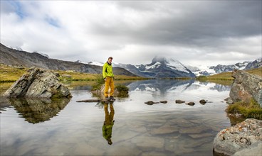 Hiker walks over stones in the water