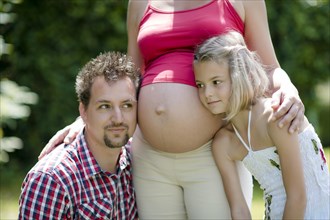 Pregnant woman with husband and daughter