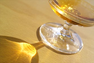 Filled Cognac glass with reflexes on table top