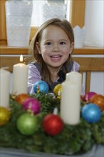Girl enjoying the first lit candle on the Advent wreath