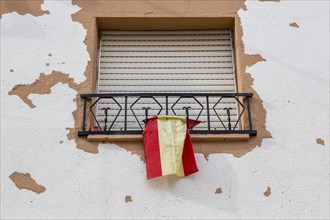 Window with closed blinds and Spanish flag