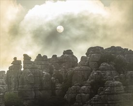 Bizarre limestone rock formations with the sun and fog