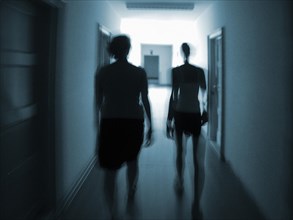 Silhouettes of two people in a hallway
