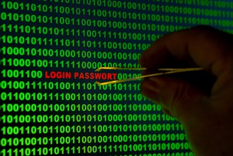 Hand reaching for the words 'Login Passwort' with tweezers in a binary code