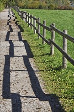 Fence with a shadow along the promenade path