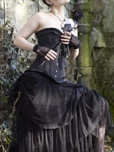 Woman with corset holding a black rose