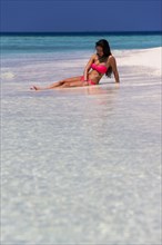 Woman in a pink bikini lying on the beach
