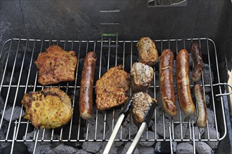 Meat and sausages or bratwursts on a grill