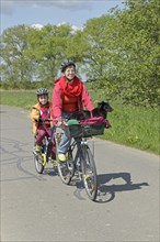 Mother and son with their dog on a cycling tour