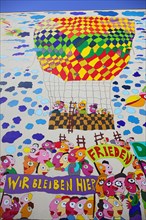 Colourful mural with the words 'Frieden' and 'Wir bleiben hier'