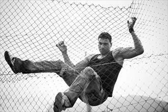 Young man climbing a fence
