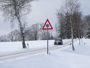 Traffic sign at a snow-covered road in winter