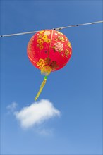 Red Chinese New Year lantern against blue sky